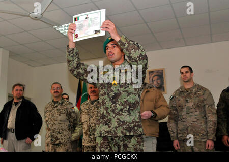 Un soldat de l'Armée nationale afghane affiche fièrement son diplôme lors d'une cérémonie tenue à l'École d'ingénieur de l'Armée nationale afghane près du Camp Spann, le 15 décembre. Quinze soldats afghans a obtenu son diplôme à la cérémonie et peut maintenant porter le patch de neutralisation des explosifs et d'un insigne à l'issue de 22 semaines de cours intensifs et de neutralisation des engins explosifs improvisés à l'encontre de la formation. Ingénieur de l'école est la seule en Afghanistan qui enseigne les fondements de la NEDEX et NEEI aux forces de sécurité afghanes. Force internationale d'assistance à la Commande régionale nationale afghane prend en charge du S Banque D'Images