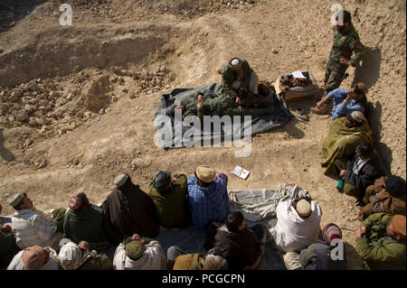 Une police locale afghane candidat montre comment appliquer une attelle pour camarades de classe lors d'une première classe d'aide dans Kajran Daykundi district, province, Afghanistan, janv. 5. Les trois semaines de l'ALP cours couvre les procédures de police de base, le maniement des armes et les autres compétences nécessaires pour protéger et défendre les citoyens afghans et de maintenir la stabilité dans la région. Banque D'Images