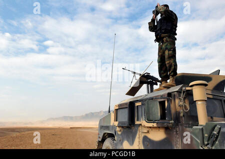 Un soldat de l'Armée nationale afghane est au sommet de son Humvee tôt le matin pour assurer la sécurité d'autres soldats au cours de la formation sur un champ de tir réel. La sécurité est également pour la protection des civils qui entourent l'éventail afin d'empêcher quiconque de marcher accidentellement à la plage durant les formations. Banque D'Images