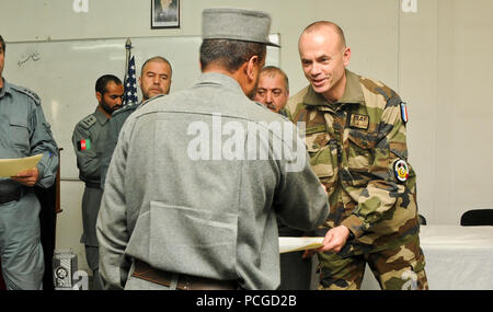 Le brig. Général Christian Dupouy, commandant adjoint de la formation de l'OTAN, sous-Command-Police Mission-Afghanistan, donne un certificat de fin d'une Police nationale afghane (PNA) stagiaire qui est diplômé de l'Afghanistan du système d'information de gestion des ressources humaines (AHRIMS) cours à au Centre de formation (CCT), le 19 mars 2013. Au cours de ces 21 jours, l'ANP a appris la base de données, de navigation, de numérisation et de processus de chargement pour mieux la méthode de dépôt de renseignements médicaux personnels, la formation et la promotion des enregistrements au cours de la carrière des individus pour aider à éliminer l'entretien physique du papier vers un ordinateur Banque D'Images