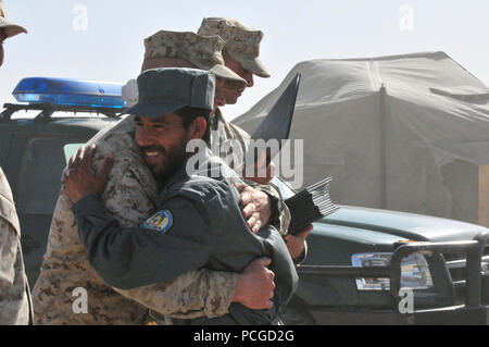 Un instructeur de perçage du Corps des Marines des États-Unis félicite diplômé de la classe de la Police nationale afghane 2010-02 après la classe' cérémonie de remise des diplômes s'est déroulée au Camp Sapadalure, Afghanistan le mercredi, 31 mars. Les marines sont le mentorat des recrues de l'ANP dans le cadre de la FIAS de l'OTAN Partenariat avec l'Afghanistan visant à développer l'autosuffisance des forces de sécurité pour le pays. Banque D'Images