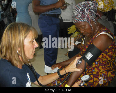 Fran Bauer, une infirmière bénévole de Project Hope, vérifie une des constantes du patient lors d'une foire de la santé sensibilisation médicale à l'appui de l'Afrique (PAA) Gare de partenariat 2012 organisé par le personnel médical américain et ghanéenne de navire à grande vitesse Swift (HSV 2). L'APS est une initiative de coopération internationale de sécurité, facilité par Commander, U.S. Naval Forces Europe-Africa, visant à renforcer les partenariats maritime mondial par le biais de la formation et des activités de collaboration afin d'améliorer la sécurité maritime et la sécurité en Afrique. Banque D'Images