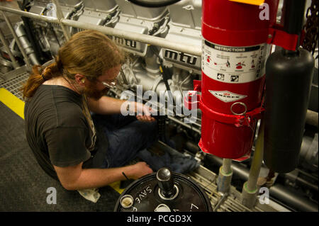 Ghana (29 mars 2014) Aaron Mackie, 3e mécanicien à bord du transport maritime militaire conjointe commande bateau à grande vitesse l'USNS Lance (JHSV 1), vérifie l'huile d'un moteur lors d'un port prévu dans le cadre d'une visite aux Etats-Unis et Ghana combiné marine maritimes d'application de la loi en vertu de l'application du droit maritime en Afrique Programme de partenariat. Banque D'Images