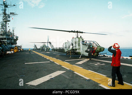 Une paire de milieu marin 164 Escadron d'hélicoptères (HMM-164) AH-1W Sea des hélicoptères Cobra se préparent à décoller de l'assaut amphibie USS TRIPOLI (LPH-10). Le tripoli est au large de Mogadiscio, en Somalie, au cours de l'effort de secours multinationales l'Opération Restore Hope. Quatre AGM-114 Hellfire missiles air-sol et un M-260 2,75 pouces rocket launcher sont montés sur le côté droit de la station d'armes/hélicoptère. Banque D'Images