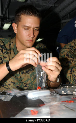 À bord du USS Tarawa (LHA 1), l'hôpital corpsman Beau Surratt, jointe à l'Équipe de débarquement du bataillon, 1er Bataillon, 5ème Marines, 11e Marine Expeditionary Unit, remplit les paquets en plastique avec des comprimés de fer pour le peuple du Bangladesh. (Le fer est pris pour prévenir l'anémie, l'incapacité du sang à coaguler correctement, causés par la malnutrition). Navire d'assaut amphibie Tarawa et entrepris 11e Marine Expeditionary Unit mènent l'aide humanitaire et secours aux sinistrés en réponse au gouvernement du Bangladesh's demande d'assistance après le cyclone tropical Sidr a frappé leur côte Sud le 15 novembre. L Banque D'Images