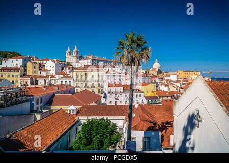 Lisbonne, Portugal. Vue sur une journée ensoleillée de Miradouro das Portas do sol sur le quartier d'Alfama. Église Sao Vicente à l'arrière. Banque D'Images