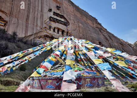 Mati Temple dans la province de Gansu en Chine et les drapeaux de prière flottant à l'avant-plan. Banque D'Images