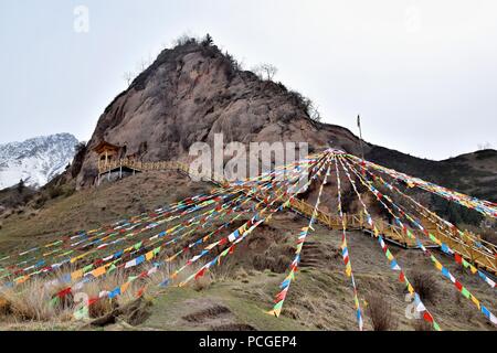 Mati Temple dans la province de Gansu en Chine et les drapeaux de prière flottant à l'avant-plan. Banque D'Images