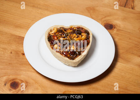 Mignon et romantique en forme de coeur tarte sucrée des couples petit-déjeuner sur un comptoir en bois et rustique fait avec amour Banque D'Images