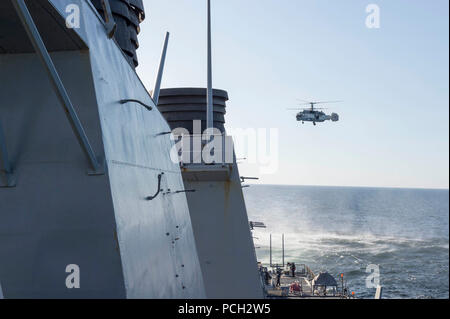 Mer - un russe Kamov KA-27 HELIX vole bas-niveau passe près de la classe Arleigh Burke destroyer lance-missiles USS Donald Cook (DDG 75) pendant que le navire se trouvait dans les eaux internationales le 12 avril 2016. Donald Cook est déployée en avant à Rota, en Espagne, et est qui effectuaient une patrouille de routine dans le domaine de la sixième flotte américaine des opérations à l'appui des intérêts de sécurité nationale des États-Unis en Europe. Banque D'Images