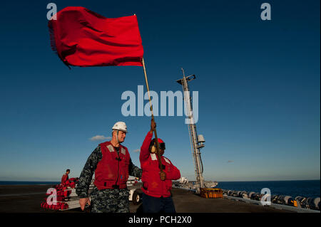 Océan Pacifique (fév. 12, 2013) Le Cmdr. Keith Rowe, armement, supervise 3 Classe Quartier-maître Samanta Petit alors qu'elle porte un drapeau comme référence de classe Nimitz le porte-avions USS Carl Vinson (CVN 70), tire sur la reconstitution de la flotte aux côtés de l'USNS lubrificateur Henry J. Kaiser (T-AO 187). Carl Vinson est en cours la réalisation du système d'atterrissage de précision (EPLA) et l'envol des certifications. Banque D'Images