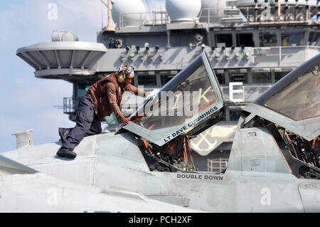 La mer d'Oman (nov. 25, 2012) d'un membre de Jay Abraham, affecté à l'Escadron d'attaque électronique des Patriotes (VAQ) 140, nettoie le couvert d'un EA-6B Prowler dans le poste de pilotage à bord de la classe Nimitz porte-avions USS Dwight D. Eisenhower (CVN 69). Dwight D. Eisenhower est déployé sur le 5e Flotte des États-Unis zone de responsabilité des opérations de sécurité maritime, la coopération en matière de sécurité dans le théâtre d'une mission de soutien et d'efforts dans le cadre de l'opération Enduring Freedom. Banque D'Images