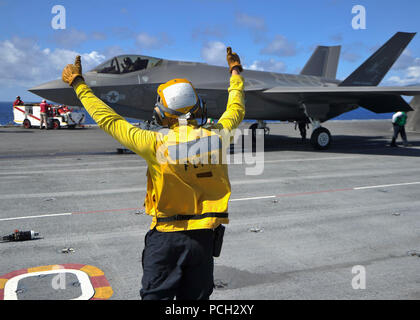 Océan Atlantique (16 août 2000 14, 2016) Un marin communique avec le pilote d'un F-35C Lightning II, variante transporteur assigné à la Grim Reapers de Strike Fighter Squadron (VFA) 101, la Marine a F-35C de l'escadron de remplacement de la flotte, sur le pont du porte-avions USS George Washington (CVN 73). VFA-101 les avions et les pilotes sont à mener les premières qualités à bord de George Washington dans l'océan Atlantique. Le F-35C est prévue pour être opérationnelle de la flotte en 2018. Banque D'Images