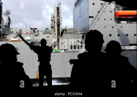 Océan Atlantique (janvier 1985). 15, 2013) Maître de Manœuvre 1re classe Stephen Markman, attribué à le porte-avions USS George H. W. Bush (CVN 77) des signaux aux membres du personnel à bord du transport maritime de marchandises sèches commande militaire et des munitions ship USNS William McLean (T-AKE 12) lors d'une munitions onload. George H. W. Bush est la formation et qualifications de l'opérateur dans l'océan Atlantique. Banque D'Images