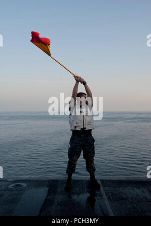 La mer d'Oman (nov. 15, 2012) matelot timonier, Shannon Kessler, attribué à le porte-avions USS JOHN C. STENNIS (CVN 74), signaux à la mission de combat militaire rapide Commande de navire USNS Bridge (T-AOE 10) au cours d'un ravitaillement en mer. John C. Stennis est déployé sur le 5e Flotte des États-Unis zone de responsabilité des opérations de sécurité maritime, les efforts de coopération en matière de sécurité dans le théâtre et missions d'appui pour l'opération Enduring Freedom. Banque D'Images