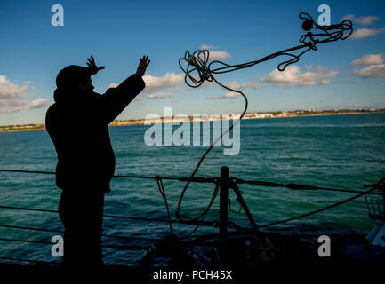 Gare ROTA, ESPAGNE (janvier 1985). 26, 2018) Seaman Chance Vaughan lance une ligne d'attrape flottante d'un remorqueur à bord de la classe Arleigh Burke destroyer lance-missiles USS Carney (DDG 64), comme le navire moors à base navale de la Rota, Espagne. Carney, l'avant-déployé à Rota, en Espagne, est sur sa quatrième patrouille dans la sixième flotte américaine zone d'opérations à l'appui des alliés et partenaires, et les intérêts de sécurité nationale des États-Unis en Europe. Banque D'Images