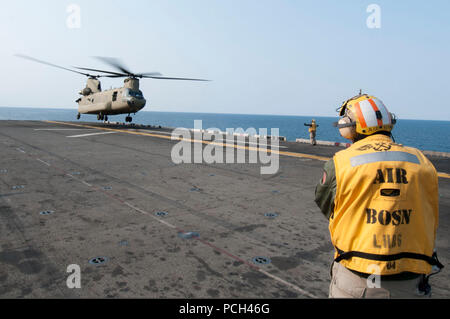 Un marin américain dirige une armée CH-47F Chinook affecté à la 3e Bataillon de l'aviation d'appui général, 2e Brigade d'aviation de combat, 2e Division d'infanterie à la terre à bord du navire d'assaut amphibie USS Bonhomme Richard (DG 6) dans la mer de Chine orientale, le 11 avril 2014. Le Bonhomme Richard était en cours aux États-Unis 7e flotte domaine de responsabilité des opérations de sécurité maritime et les efforts de coopération en matière de sécurité dans le théâtre. Banque D'Images