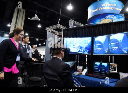 NATIONAL Harbor, MD (16 mai 2016) Lauren Burnette, du Space and Naval Warfare Systems Command (SPAWAR) Systems Centre Pacifique, explique l'espace de bataille l'exploitation de la réalité mixte (BEMR) Lab démo pour un visiteur à l'Office of Naval Research (ONR) au cours de l'exposition 2016 Sea-Air-Space Exposition. BEMR est conçu pour présenter et démontrer à faible coût à la fine pointe de la réalité mixte commercial, la réalité virtuelle et les technologies de réalité augmentée et de fournir une installation où guerriers, les chercheurs, le gouvernement, l'industrie et les universités peuvent collaborer. Banque D'Images