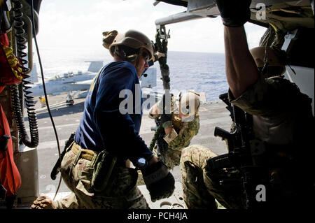 Océan Pacifique (avril 25,2013) Un technicien des explosifs et munitions équipe fait des manoeuvres de corde rapide d'un MH-60S Knight Hawk à l'hélicoptère de combat Eightballers Mer Escadron (HSC) 8 lors d'une démonstration de puissance de l'air à bord du porte-avions USS JOHN C. STENNIS (CVN 74). Le John C. Stennis, groupe composé de Stennis, CVW-9, 21 destroyers lance-missiles et cruiser USS Mobile Bay (CG-53), est de retour d'un déploiement de 8 mois aux États-Unis 5e et 7e flotte domaines de responsabilité. Banque D'Images