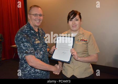 BANGOR, Washington (septembre 1994). 21, 2016) - Le Capitaine Alan Schrader, Naval Base Kitsap (NBK) commandant, machiniste de l'Aviation présente Mate Airman Antonia Holland avec un frocking (promotion) Lettre à maître de troisième classe pendant un appel mains tenue à la NBK-Bangor Cinema Theatre Plus. Plus de 30 prix et décorations ont été décernées aux marins lors de l'occasion. Il a été le premier tout-Schrader appel comme halls NBK CO. Banque D'Images