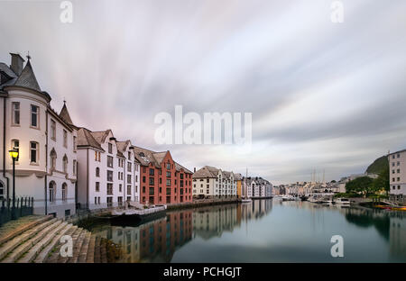 Vue sur le bâtiments Art Nouveau reflète dans l'eau au lever du soleil à Alesund, Norvège. Banque D'Images