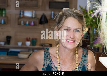 Portrait of young woman smiling blonde française dans son magasin de cadeaux faits main en France, entrepreneur concept. Banque D'Images