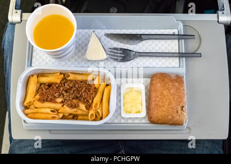 Un repas en vol - déjeuner avec du jus d'orange et les pâtes à bord de la classe économique d'une compagnie aérienne allemande.vue d'en haut. Banque D'Images