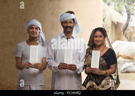 Les agriculteurs ruraux indiens family holding chèque bancaire Banque D'Images