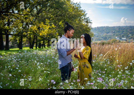 Couple holding hands in a field Banque D'Images