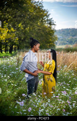 Couple partageant un moment spécial dans un champ de fleurs Banque D'Images