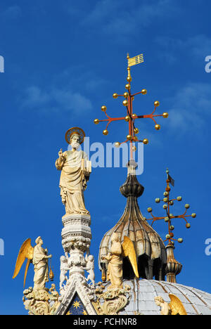 Parmi les statues de Saint-marc anges gothique spire en haut de la cathédrale de style byzantin Venise avec dôme en arrière-plan (13-14 ème siècle) Banque D'Images