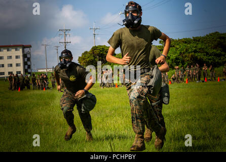 Le Cpl. Ian Parrott sprints vers la chambre à gaz à Futenma Marine Corps Air Station, Okinawa, Japon, Juillet 26, 2018. Chaque année, les Marines sont tenus de s'entraîner dans la chambre à gaz à bâtir la confiance. Les Marines ont besoin d'être préparé à l'éventualité d'une attaque au gaz ainsi lui ou elle peut réagir calmement et correctement don son masque. Parrott, Huntsville, Alabama, est un produit chimique, biologique, radiologique et nucléaire Défense sous-officier responsable du bataillon logistique de combat avec 4, 3 Régiment de logistique de combat, 3e Groupe logistique maritime. (U.S. Marine Corps photo par le Cpl. Andy O. Martinez) Banque D'Images