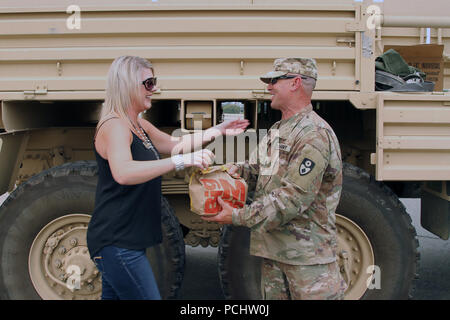 Redding, Californie Heidi résident Meeks, un prêt hypothécaire auteur et grand fan de la Garde nationale de Californie, de l'alimentation présente le sergent de l'Armée américaine Jeff couches de la 649e compagnie du génie, 579e bataillon du génie, 49e Brigade de police militaire, le 30 juillet au cours de l'incendie de Carr. Résidants continuent d'exprimer leur gratitude à Cal garde pour leurs efforts pour aider à la récupération de la ville. (U.S. Photo de la Garde nationale par le sergent. Eddie Sigüenza) Banque D'Images