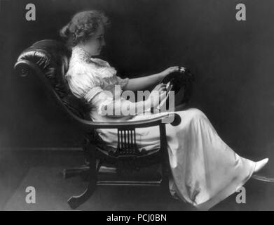 Helen Keller, portrait en pied assis dans une chaise de salon tenant un vase de la main gauche et la toucher avec sa main droite en 1909. Helen Keller (27 juin 1880 - 1 juin 1968) était un écrivain, activiste politique, et conférencier. Elle a été la première personne atteinte de surdi-cécité à gagner d'un baccalauréat. Banque D'Images