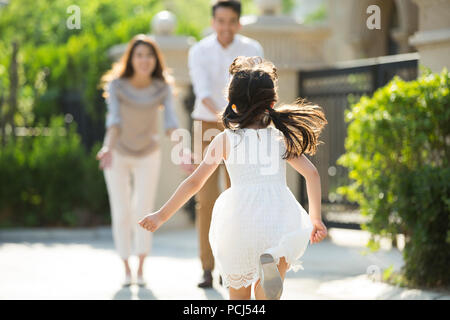 Happy little Chinese girl courir vers ses parents Banque D'Images