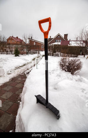 Pelle à neige dans la neige pendant la tempête de neige. Pelle pour le nettoyage des sentiers de neige. Banque D'Images