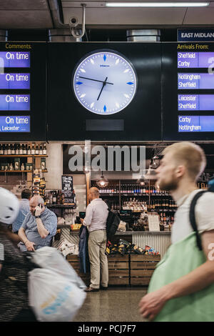 Les gens assis à un café, en attente de leur départ des trains sous le bord intérieur de la gare St Pancras, London, UK. Banque D'Images