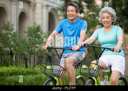 Cheerful senior couple riding bikes chinois Banque D'Images