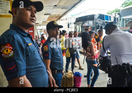 Quezon City, Philippines. 06Th Aug 2018. Alerte renforcée. La police est sur la bonne voie alors qu'il effectuait une inspection des passagers les effets personnels à l'Araneta Cubao, Centre de la station de bus sur le jeudi 2 août 2018. Crédit : Robert Oswald Alfiler/Pacific Press/Alamy Live News Banque D'Images