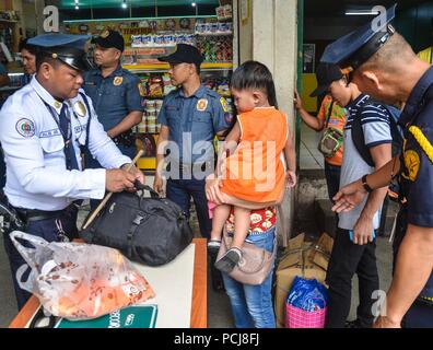 Quezon City, Philippines. 06Th Aug 2018. Alerte renforcée. La police est sur la bonne voie alors qu'il effectuait une inspection des passagers les effets personnels à l'Araneta Cubao, Centre de la station de bus sur le jeudi 2 août 2018. Crédit : Robert Oswald Alfiler/Pacific Press/Alamy Live News Banque D'Images