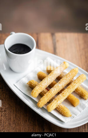 Churros con chocolate espagnol traditionnel petit-déjeuner sucré mis sur table en bois Banque D'Images