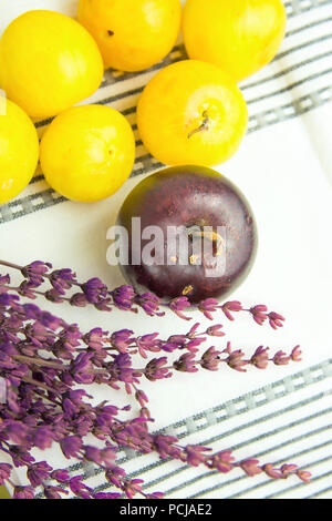 Tas de matières organiques juteux mûres prunes rouges jaune bouquet de fleurs de lavande serviette en coton blanc sur. Automne Automne produire. Des couleurs vives. Provence kitch rural Banque D'Images