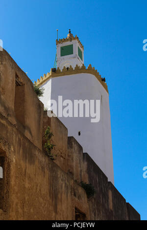 Haut de la tour de grande Mosquée de l'ancienne forteresse portugaise d'El Jadida, Maroc. Mur d'une haute clôture en premier plan. Ciel bleu. Banque D'Images