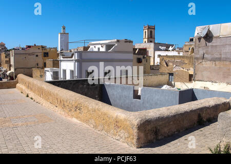 Toits et murs de l'immeuble d'habitations et d'une tour de grande mosquée de ancienne forteresse portugaise à El Jadida, Maroc. Ciel bleu. Banque D'Images