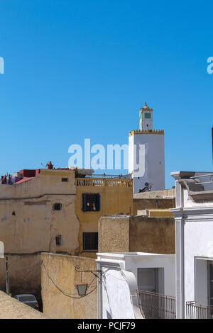 Toits et murs de l'immeuble d'habitations et d'une tour de grande mosquée de ancienne forteresse portugaise à El Jadida, Maroc. Ciel bleu. Banque D'Images