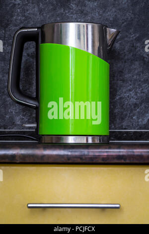 Une bouilloire électrique vert se dresse sur la table de cuisine close-up. Banque D'Images