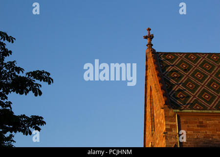 Détail de la cathédrale de Bâle (l'église et de l'ancienne cathédrale) à Bâle, Suisse. Halo rouge et jaune, dans le coucher du soleil. Banque D'Images