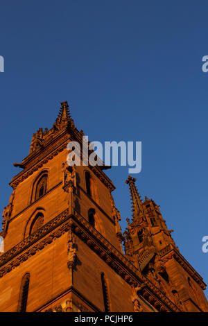 Tour de la cathédrale de Bâle (l'église et de l'ancienne cathédrale) à Bâle, Suisse. Halo rouge et jaune, dans le coucher du soleil. Banque D'Images