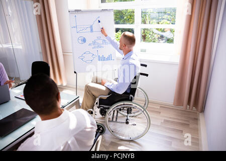 Les Jeunes Handicapés Businessman Giving presentation de son collègue Banque D'Images