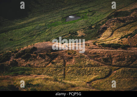 Randonneur sur le sentier de Holyrood Park, Salisbury Crags et Arthur's Seat au coucher du soleil. Edinburgh, Ecosse, Royaume-Uni. Banque D'Images